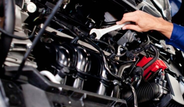 A mechanic meticulously works on a vehicle's engine