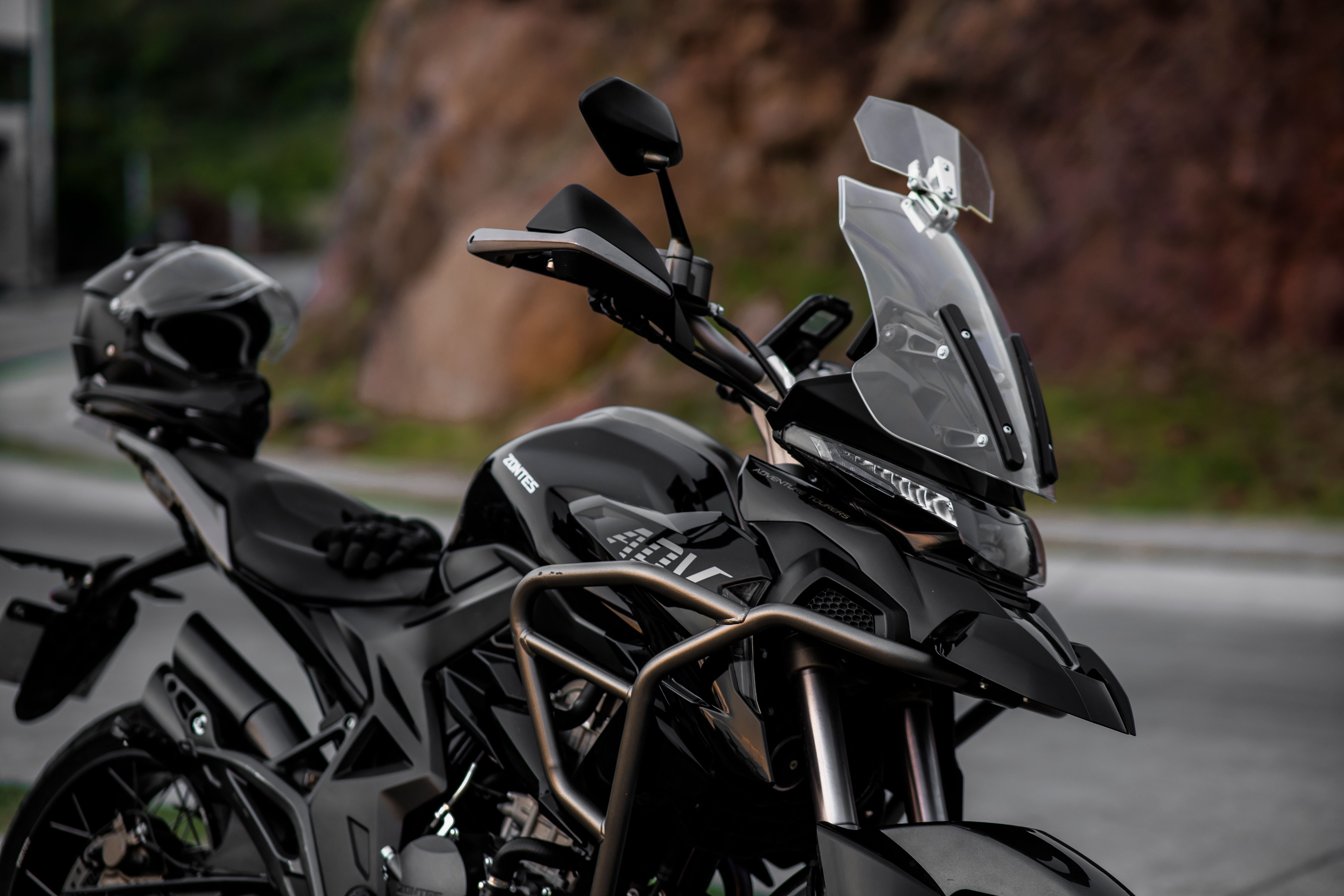 Close-up of a parked black adventure touring motorcycle with a factory windshield