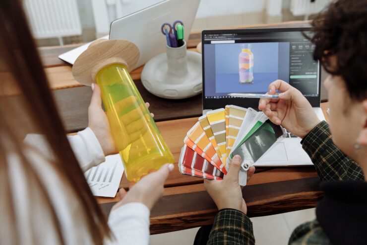Packaging designers collaborating over color swatches and digital bag mockups in a modern studio